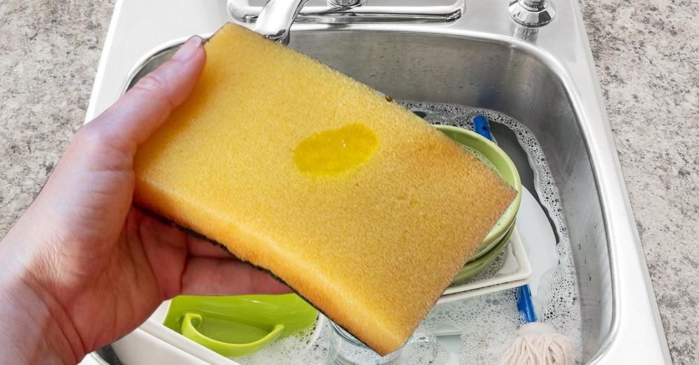 Spugna con pallina di sapone giallo pronta per essere usata sui piatti